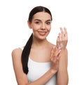 Young woman applying body cream onto her arm against white background Royalty Free Stock Photo