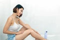 Young woman applying body lotion on her legs. Royalty Free Stock Photo