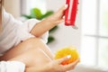 Young woman applying body lotion on legs Royalty Free Stock Photo