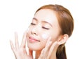 Young woman applying cosmetic cream on her face Royalty Free Stock Photo