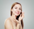 Young woman applying cream on her clear skin. Beautiful female face. Facial treatment and skin care concept Royalty Free Stock Photo