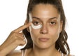 Young woman applying face cream under heer eyes