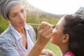 Young woman applying face paint