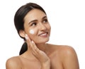 Young woman applying facial cream on white background Royalty Free Stock Photo