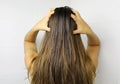 Young woman applying hair oil with her fingers. Oiling hair before washing. Hair care concept