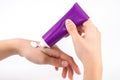 Nurturing Beauty: Young Woman Applying Hand Cream from a Purple Tube