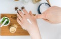 Young woman is applying homemade cosmetics on her skin