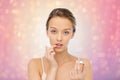 Young woman applying lip balm to her lips Royalty Free Stock Photo