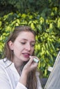 A young woman applying a lipstic