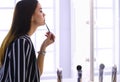 Young woman applying lipstick in front of a mirror Royalty Free Stock Photo