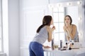 Young woman applying lipstick in front of a mirror Royalty Free Stock Photo