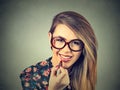 Young woman applying lipstick on gray wall background Royalty Free Stock Photo