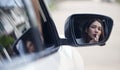 Young woman applying lipstick looking at reflection in car mirror Royalty Free Stock Photo