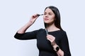 Young woman applying mascara on her eyelashes, on white background Royalty Free Stock Photo