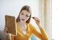 Young Woman Applying Mascara Holding Mirror Making Makeup At Home Royalty Free Stock Photo