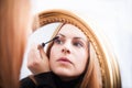 Young woman applying mascara