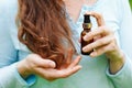 Young woman applying natural organic essential oil on hair. spa and beauty rituals. Skin care