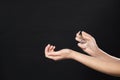 Young woman applying perfume on wrist against black background Royalty Free Stock Photo