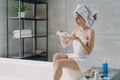 Female apply skincare anticellulite lotion doing body care routine in bathroom. Spa cosmetics ad