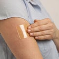 YOUNG WOMAN APPLYING TRANSPARENT NICOTINE PATCH TO ARM