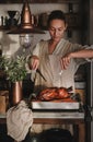 Young woman carving whole oven roasted duck for Thanksgiving