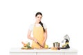 young woman in apron cutting apple at table with mixer vegetables jars with puree Royalty Free Stock Photo