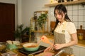Young woman in apron preparing spaghetti sauce in cozy kitchen Royalty Free Stock Photo