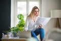 Young woman architect sitting at the desk indoors in home office, working.