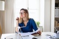 Young woman architect sitting at the desk indoors in home office, working. Royalty Free Stock Photo