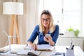 Young woman architect sitting at the desk indoors in home office, working. Royalty Free Stock Photo