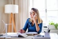 Young woman architect sitting at the desk indoors in home office, working. Royalty Free Stock Photo