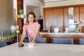 Young woman arranging chips in bowl on dining table in open-plan kitchen, with balloon decorations Royalty Free Stock Photo