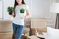 Young woman arranging flower pots in new apartment Royalty Free Stock Photo