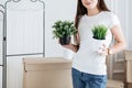 young woman arranging flower pots in new apartment Royalty Free Stock Photo