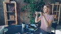 Young woman is arranging pictures, take-out coffee, sun glasses, professional camera and marker on table and shooting Royalty Free Stock Photo