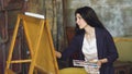 Young woman artist draw pictrure with watercolor paints and brush on easel canvas Royalty Free Stock Photo