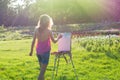 A young woman artist holds a brush and paints a picture on an ea Royalty Free Stock Photo