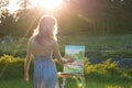 The painter paints oil paintings in the garden at sunset Royalty Free Stock Photo