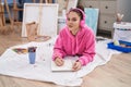 Young woman artist listening to music drawing on notebook at art studio Royalty Free Stock Photo