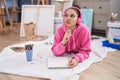 Young woman artist listening to music drawing on notebook at art studio Royalty Free Stock Photo