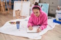 Young woman artist listening to music drawing on notebook at art studio Royalty Free Stock Photo