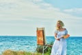 Young woman artist in the open air by the sea Royalty Free Stock Photo