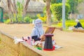 A young woman artist paints plein air in a city park