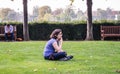 Young woman artist ponders her subject in the Tuileries, Paris.