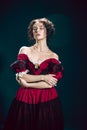 Young woman as Anna Karenina on dark blue background. Retro style, comparison of eras concept.