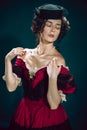 Young woman as Anna Karenina on dark blue background. Retro style, comparison of eras concept.