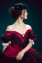 Young woman as Anna Karenina on dark blue background. Retro style, comparison of eras concept.