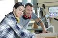 young woman as apprentice in wood construction learns with luthier Royalty Free Stock Photo