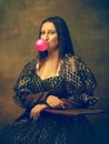 Young woman as Mona Lisa on dark background. Retro style, comparison of eras concept.