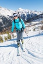 Young woman ascending a slope on skis.